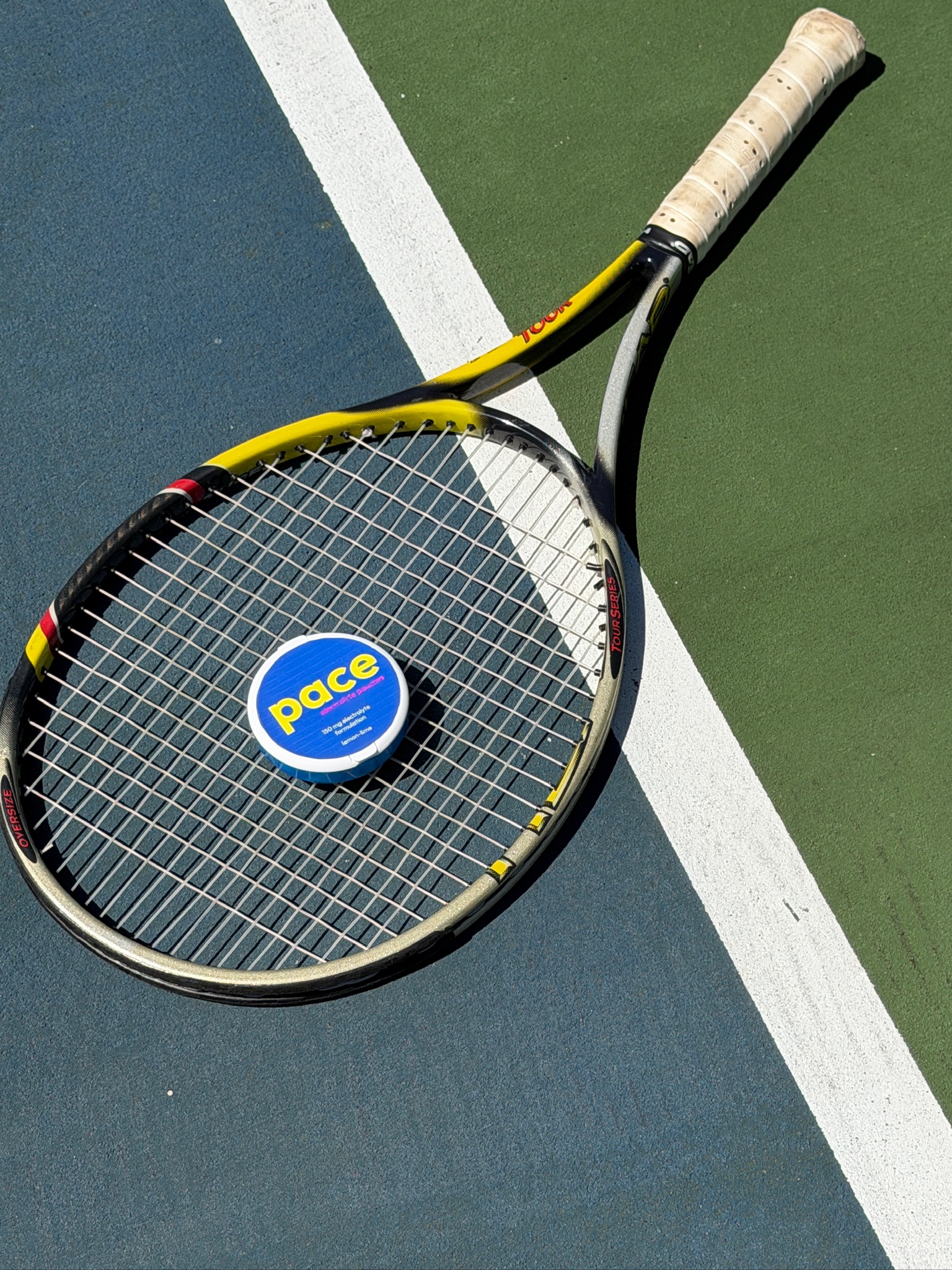 Pace electrolyte pouch on a tennis racquet at the baseline